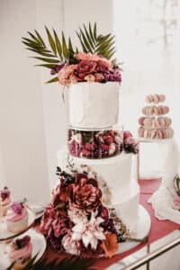 Sweets-Tabel mit Macarons, Cupcakes und Hochzeitstorte